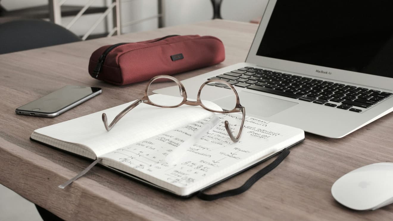 Defter, gözlük ve çalışma masası